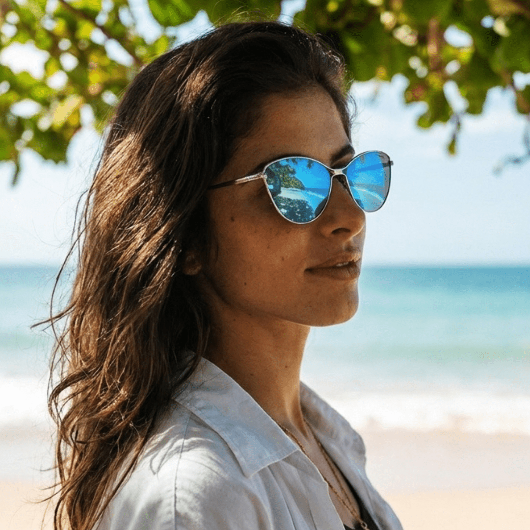 Woman wearing sunglasses with a beach and ocean background