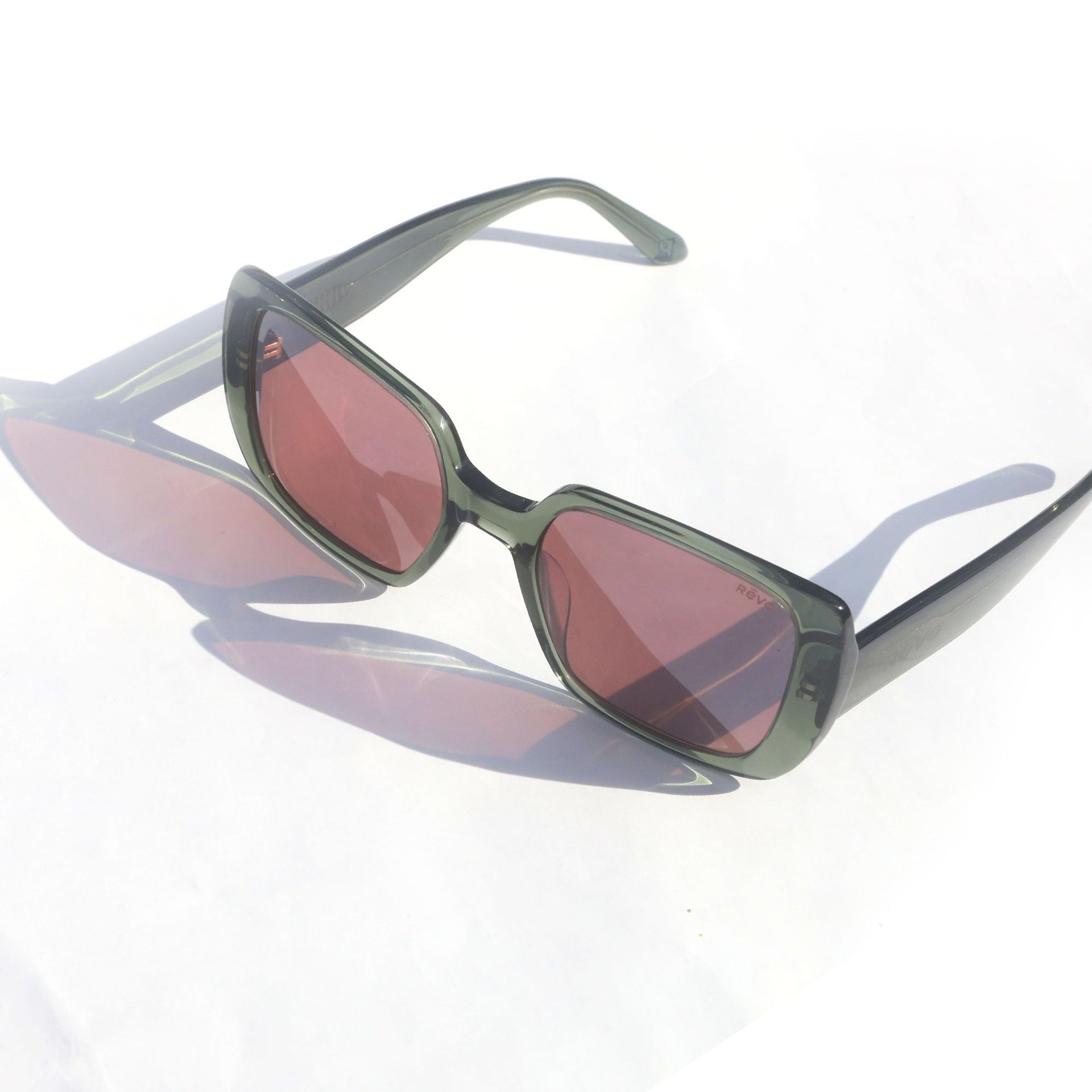 Sunglasses with red-tinted lenses on a white background