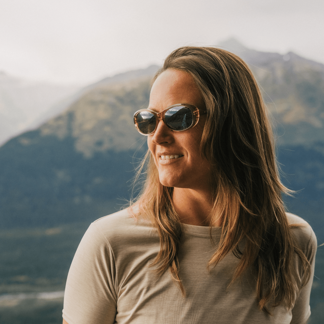 Person wearing sunglasses with mountains in the background